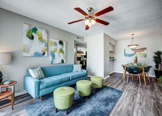 a living room with a blue couch and green chairs at Sundance Apartments, College Station, 77840