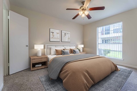 A bedroom with a large bed and a ceiling fan.