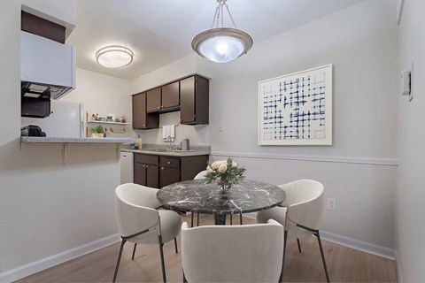 A kitchen with a table and chairs in the foreground.