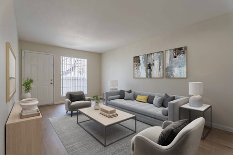 A living room with a grey couch, a grey armchair, a coffee table, a lamp, and two paintings on the wall.