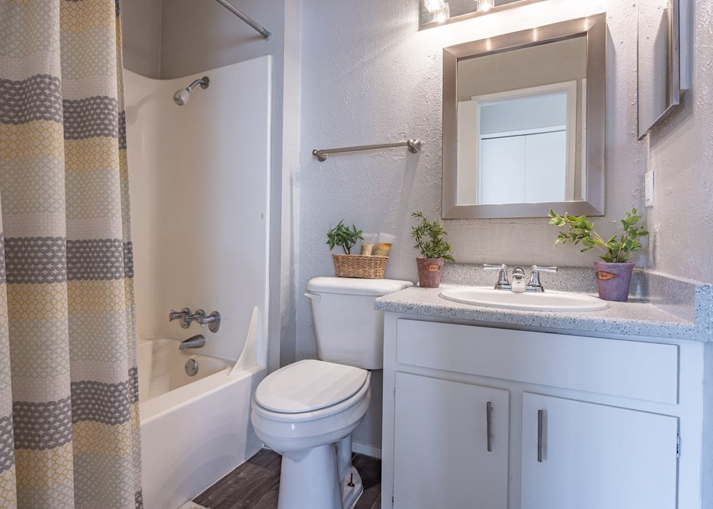 Bathroom with a white toilet next to a white bathtub  at Willow Oaks, Bryan, TX