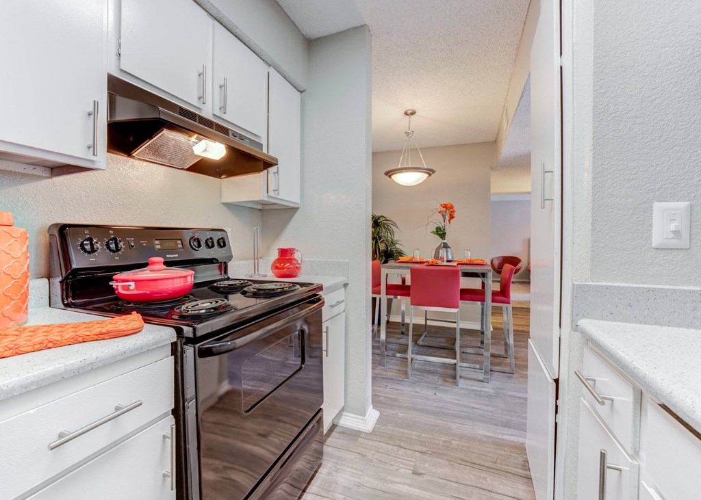a kitchen with an oven and a stove and a dining room at Sundance and Sausalito Apartments, College Station, Texas
