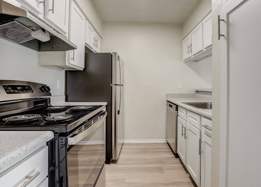an empty kitchen with white cabinets and stainless steel appliances at Sundance and Sausalito Apartments, College Station, TX