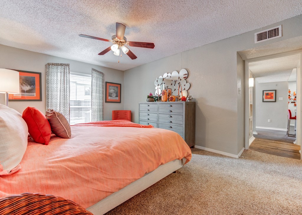 the master bedroom has a large bed and a ceiling fan at Sundance and Sausalito Apartments, College Station, 77840
