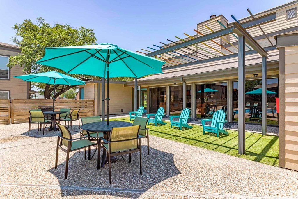 a patio with tables and chairs and umbrellas at Sundance and Sausalito Apartments, College Station, TX, 77840