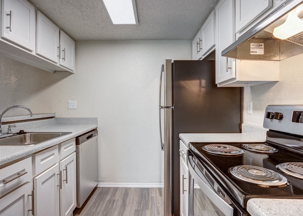 an empty kitchen with white cabinets and a stainless steel refrigerator at Sundance and Sausalito Apartments, College Station, TX, 77840