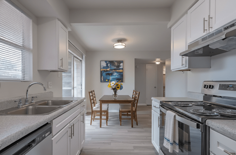 A kitchen with a table and chairs in the middle.