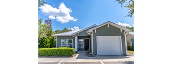 a green house with a white garage door
