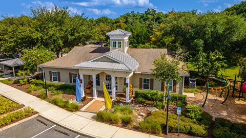 an aerial view of a house with a playground and trees
