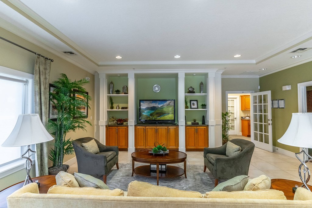 a living room with a couch and chairs and a tv