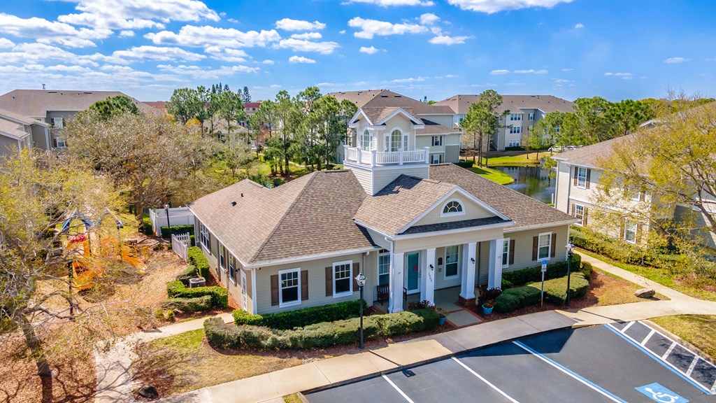 an aerial view of a house with a pool and other houses