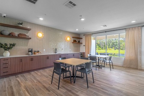 A kitchen with a table and chairs in front of a window.