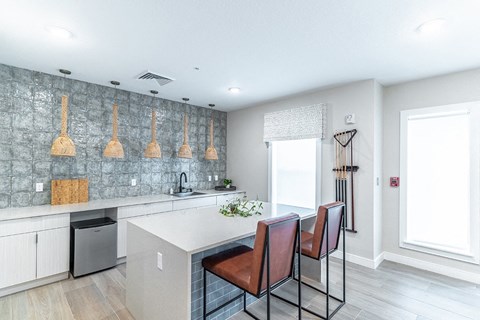 a kitchen with an island and three chairs in front of a counter
