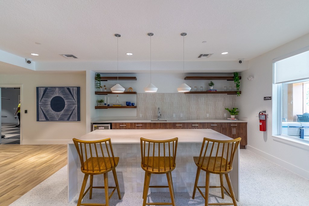A kitchen with a table and chairs in the middle.