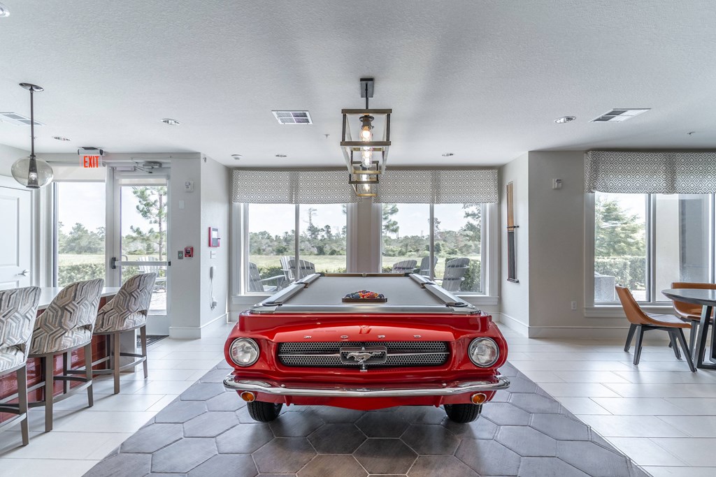 a pool table with a red car in the middle of it