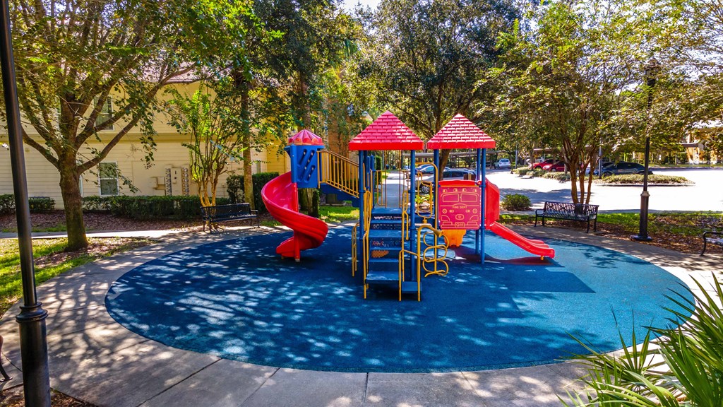 a childrens play park with a blue pool and red slides