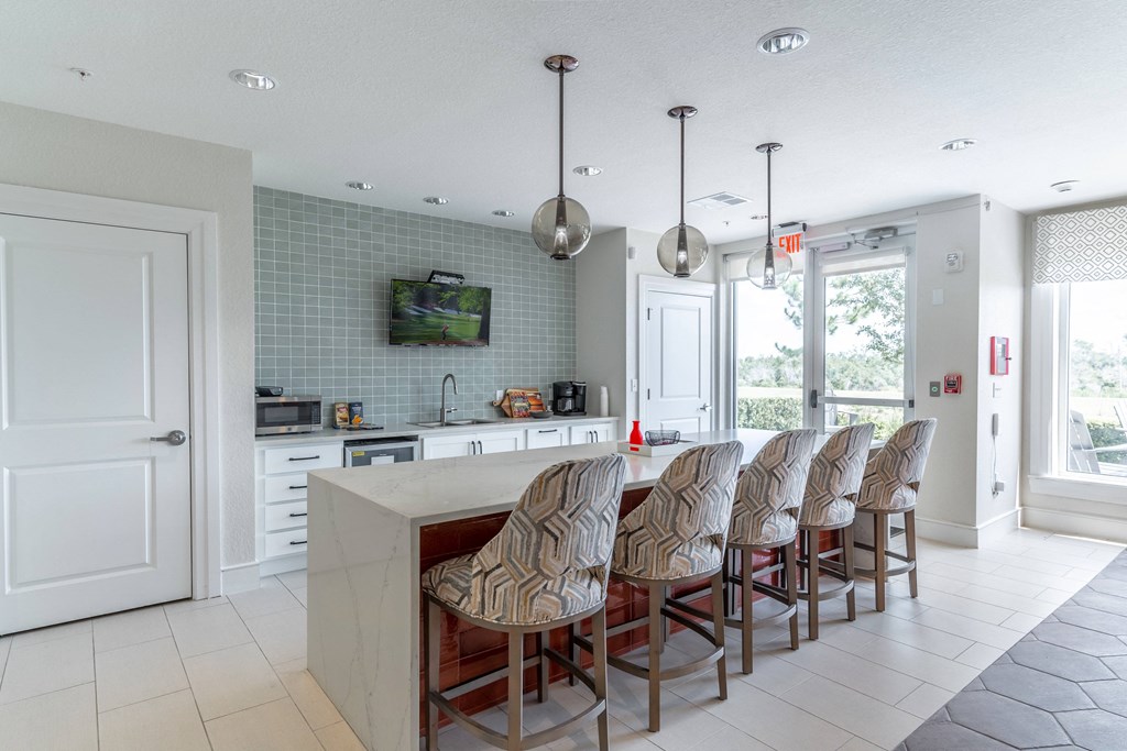 a kitchen with a long counter and a tv on the wall