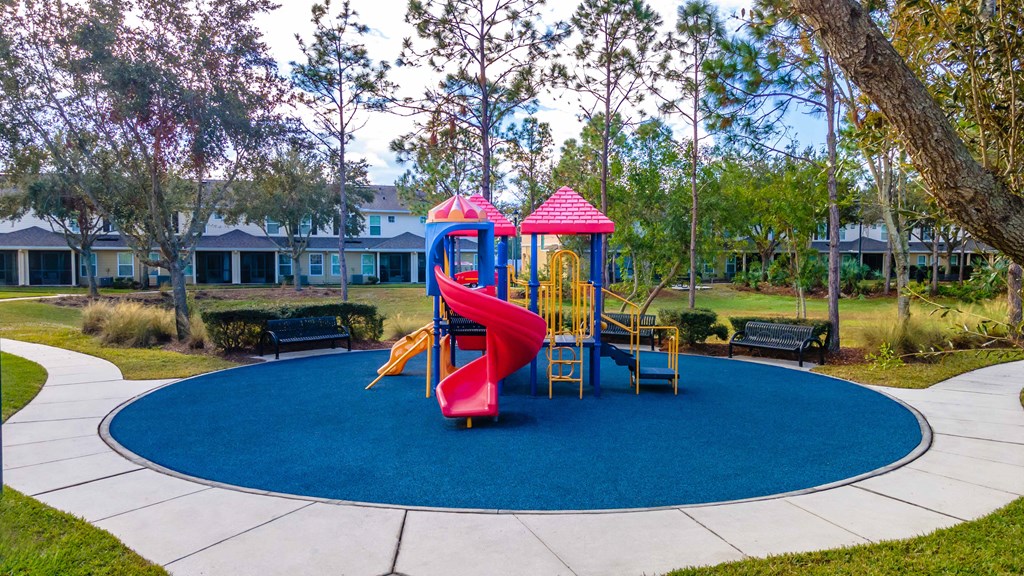 A playground with a red slide and a yellow slide.