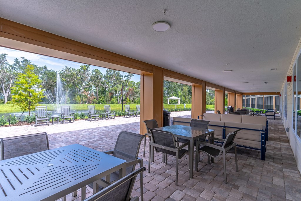A patio with a table and chairs overlooking a garden.