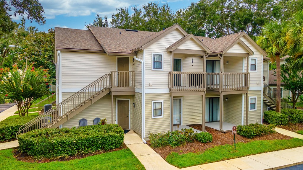 A two-story apartment building with a brown roof and beige walls.