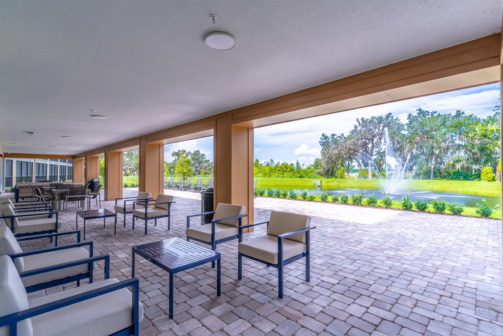 A patio with a table and chairs overlooking a garden.