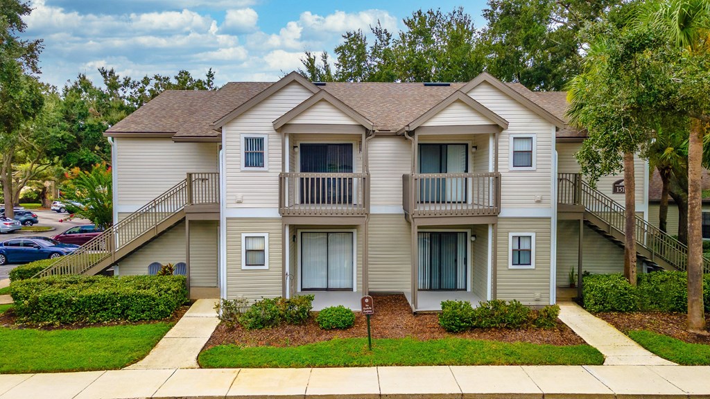 A two-story apartment building with a balcony on the second floor.