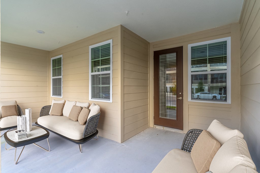 the front porch of a home with couches and a coffee table
