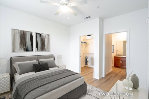 A bedroom with a large bed and a painting on the wall.