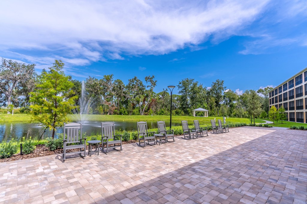 A park with a fountain, benches, and trees.