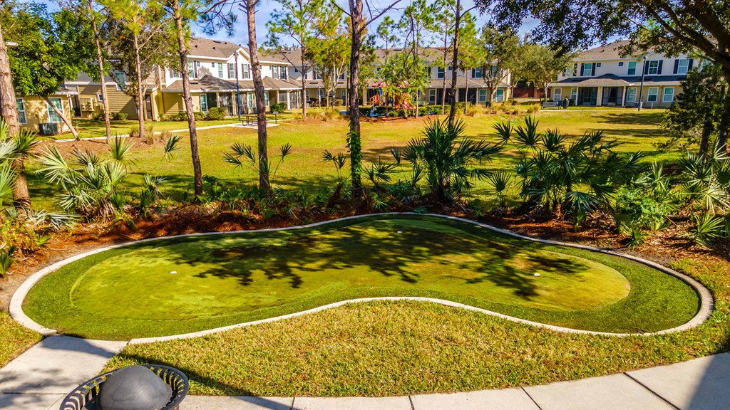 A well-manicured lawn with a white border and a curved walkway in the middle.