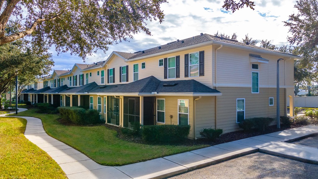 A row of houses with green bushes in front.