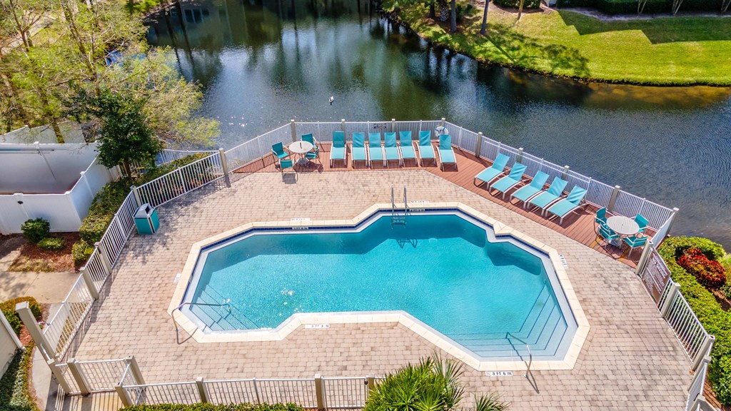an aerial view of a swimming pool and patio with chairs