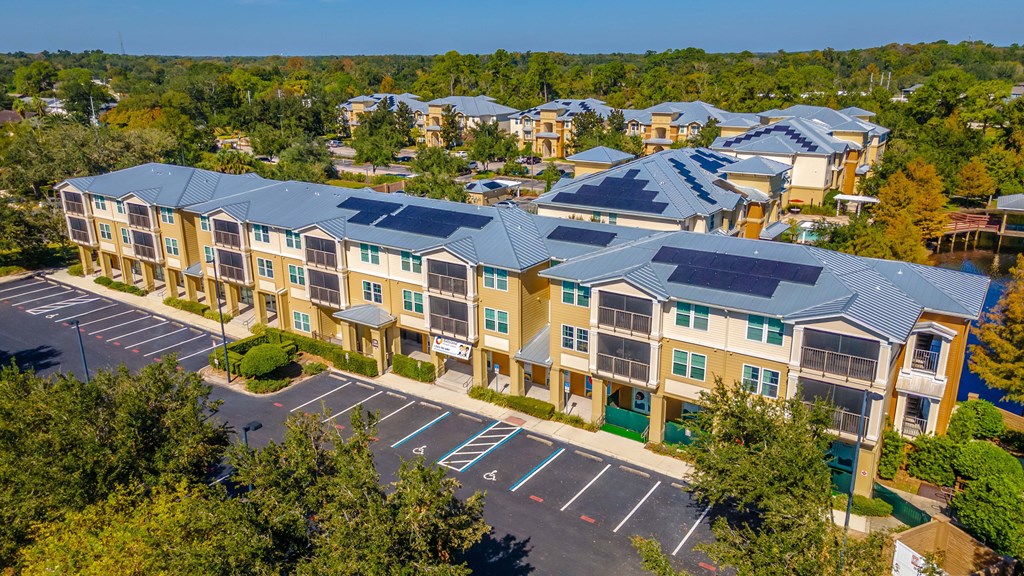 A large apartment complex with a parking lot in front.