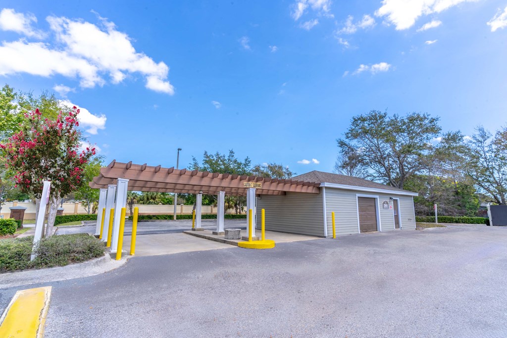 a parking lot with a building and a covered parking lot