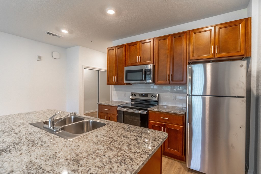 A kitchen with granite countertops and stainless steel appliances.