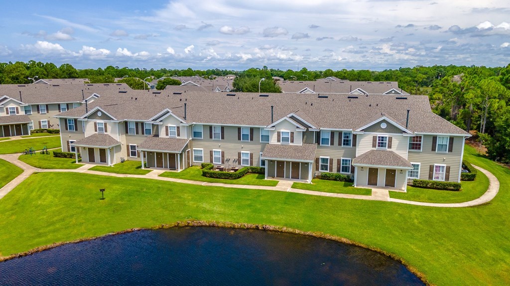 A large building complex with a pond in front.
