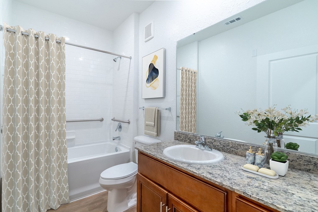 A white bathroom with a toilet, sink, and shower.