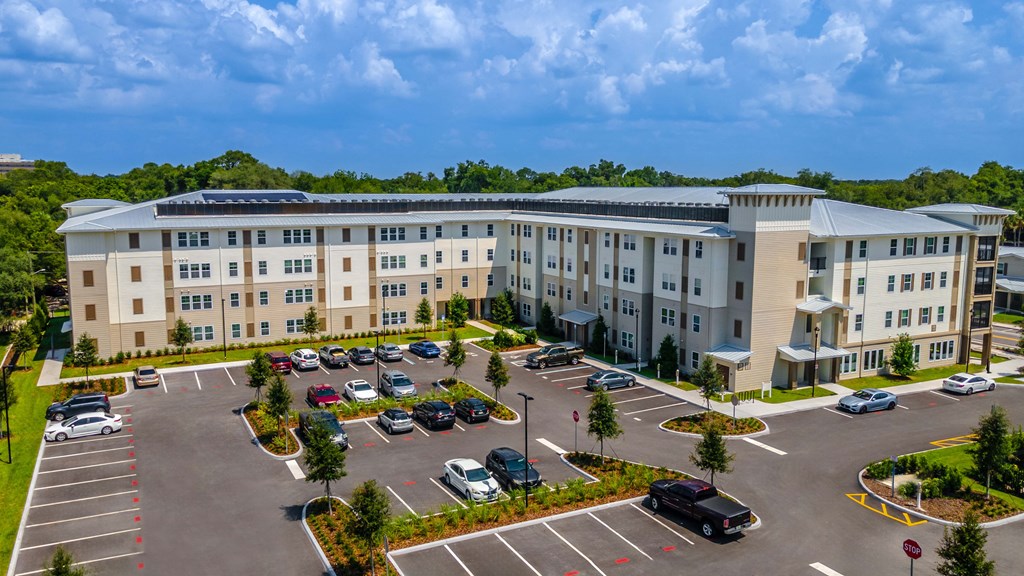an aerial view of an apartment building with a parking lot
