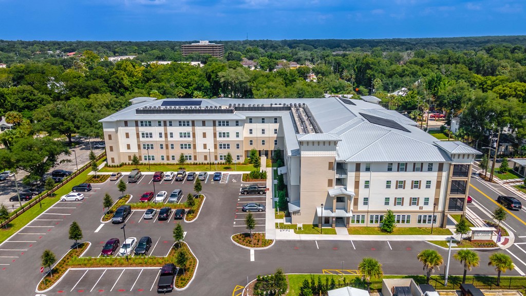 an aerial view of an apartment building and parking lot