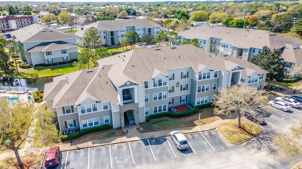an aerial view of a large building with cars parked in front of it
