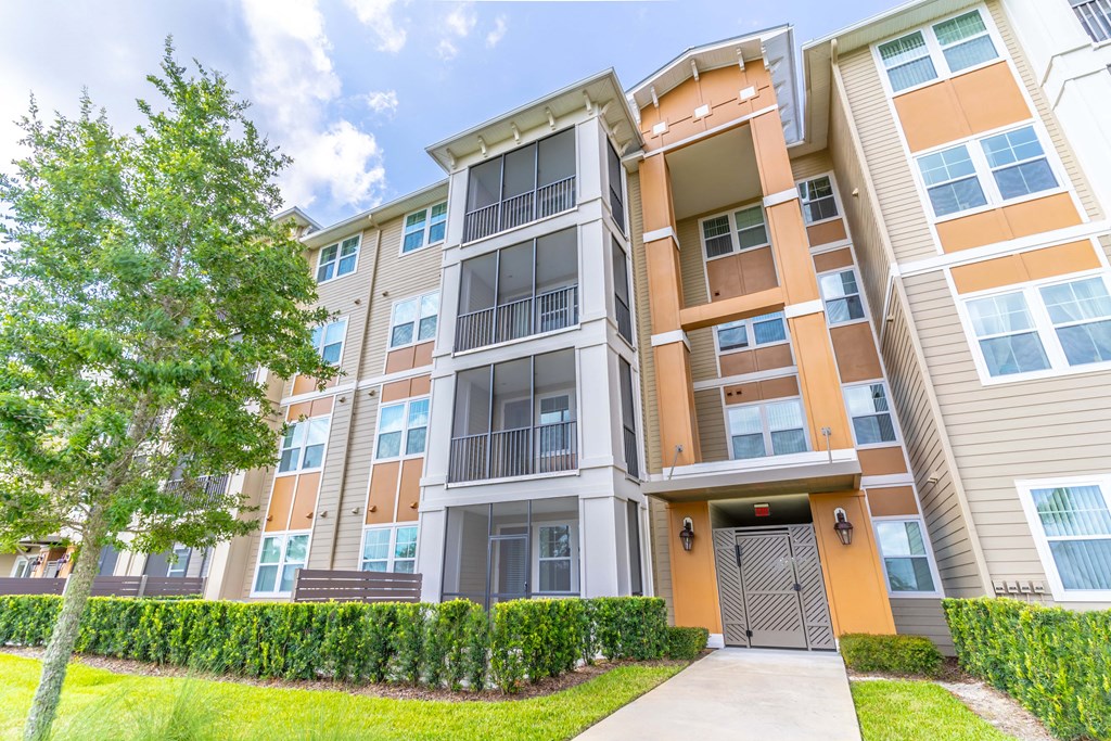 a large apartment building with a tree in front of it