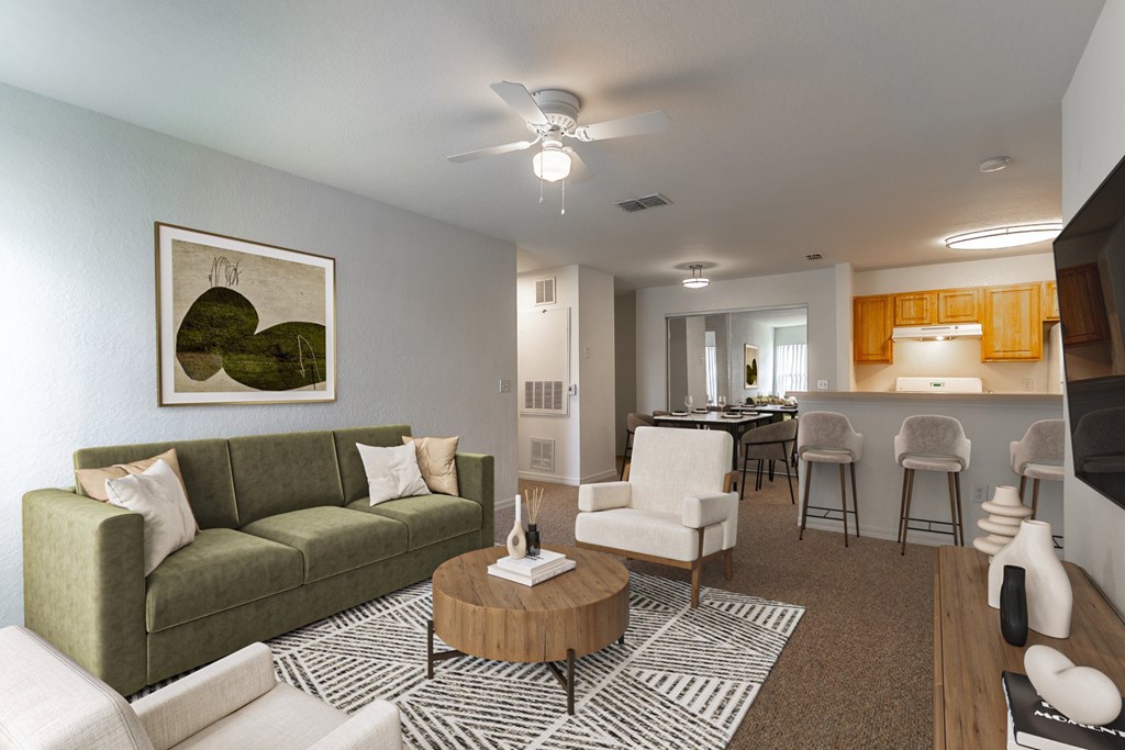A living room with a green couch, a coffee table, and a painting on the wall.