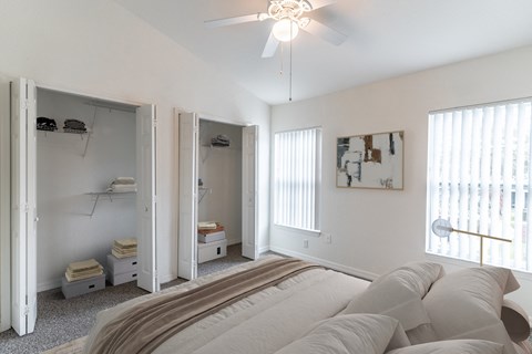 A bedroom with a large bed and a ceiling fan.