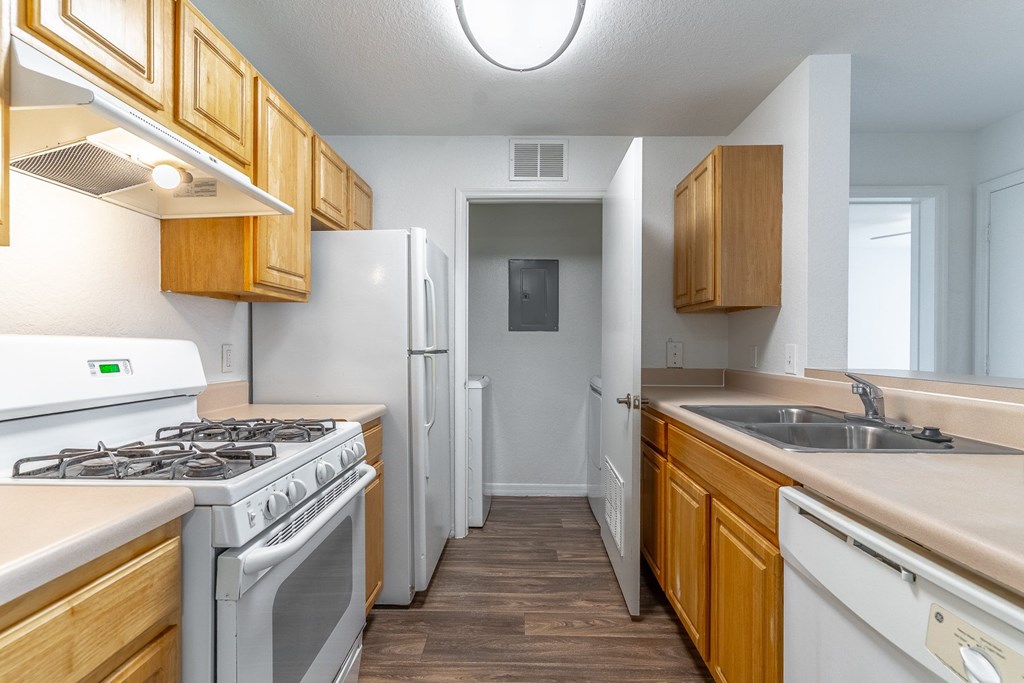 A kitchen with a white stove and white refrigerator.