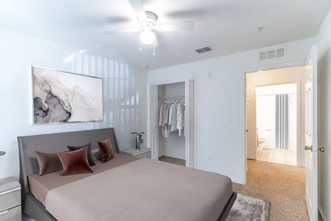 A bedroom with a large bed and a painting on the wall.