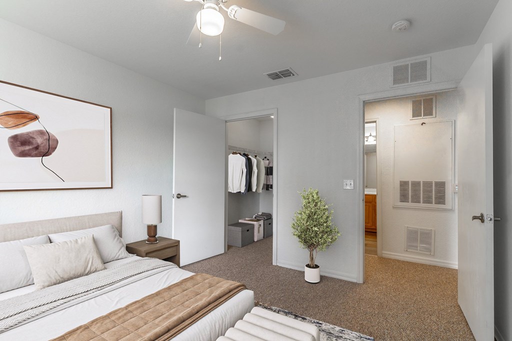 A bedroom with a large bed and a painting on the wall.