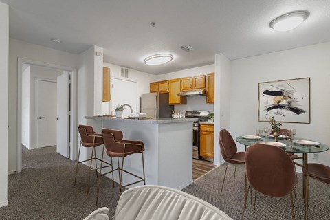 A kitchen with a dining table and chairs.