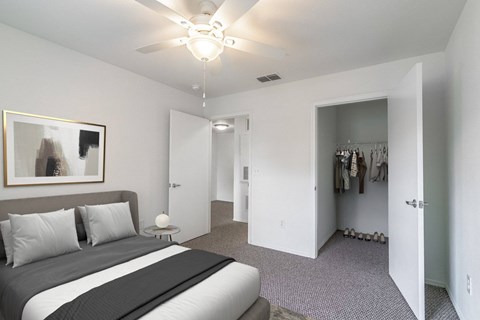 A bedroom with a large bed and a ceiling fan.