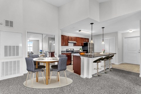 A modern kitchen with a dining table and bar stools.