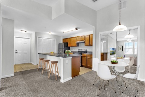 a kitchen with a breakfast bar and a table with chairs